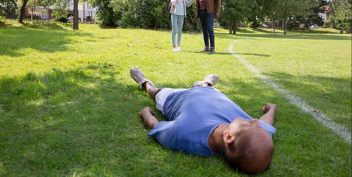 If a person suddenly drops and stays down, what is the absolute FIRST move you need to make?